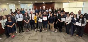 A group of award recipients pose with board members at the Governing Board meeting.