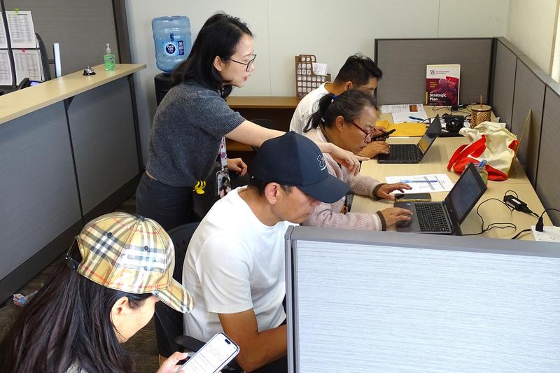 A district translator assists a family in the new Enrollment Center.
