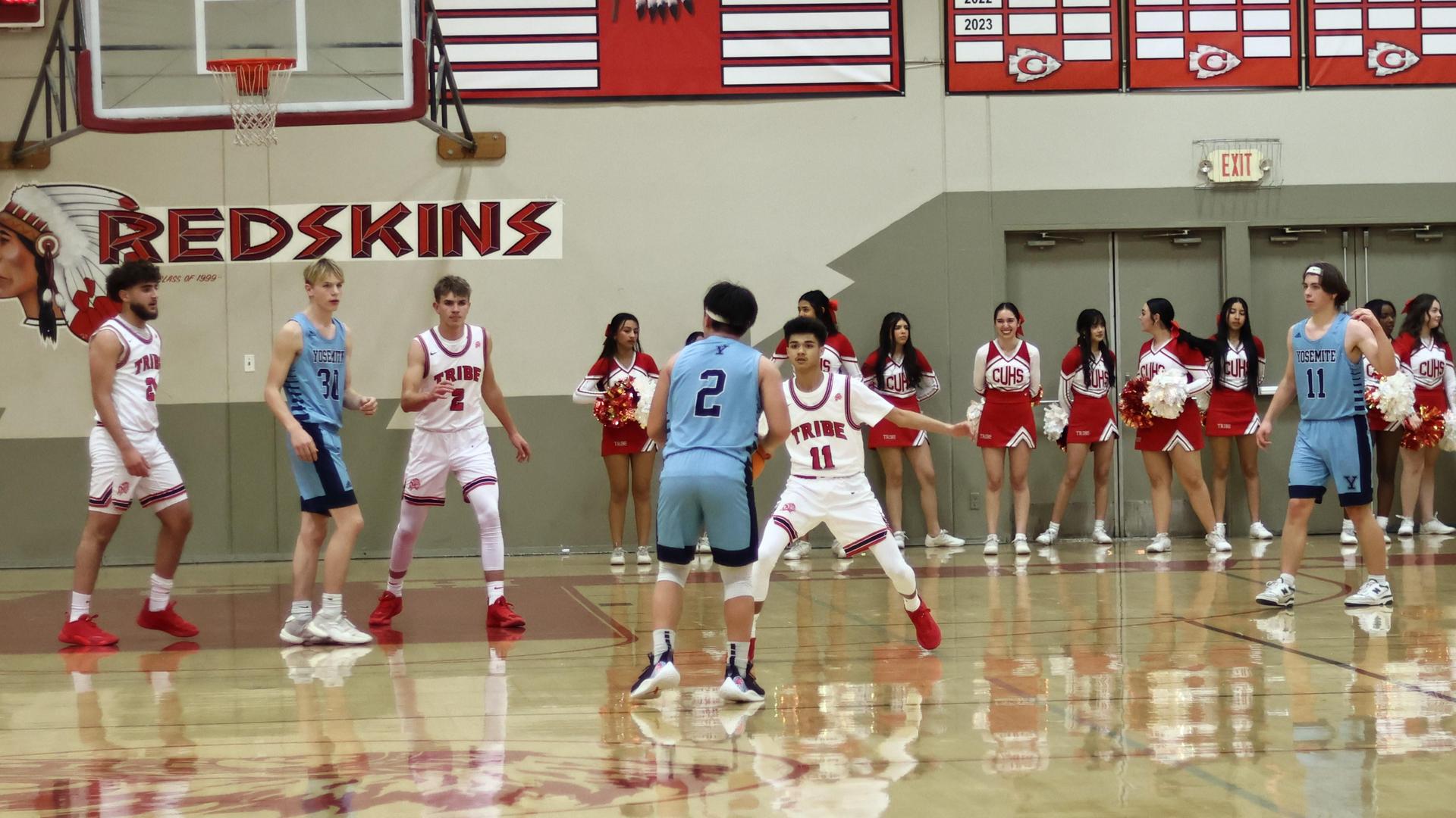 Varsity boys playing basketball against yosemite
