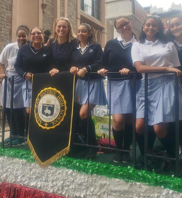 School Pres. in Navy Blue and Girls in White tops blue skirts on parade float