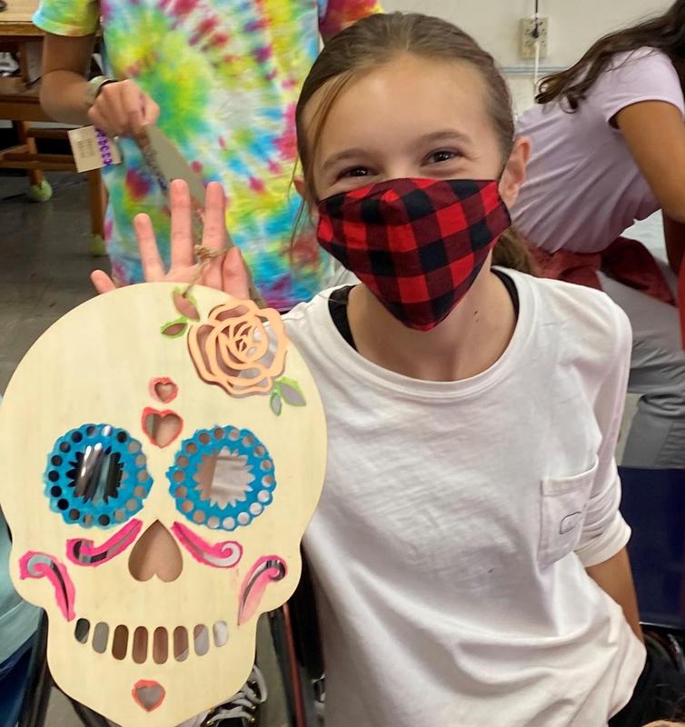 Photo of student holding artwork for dia de los muertos