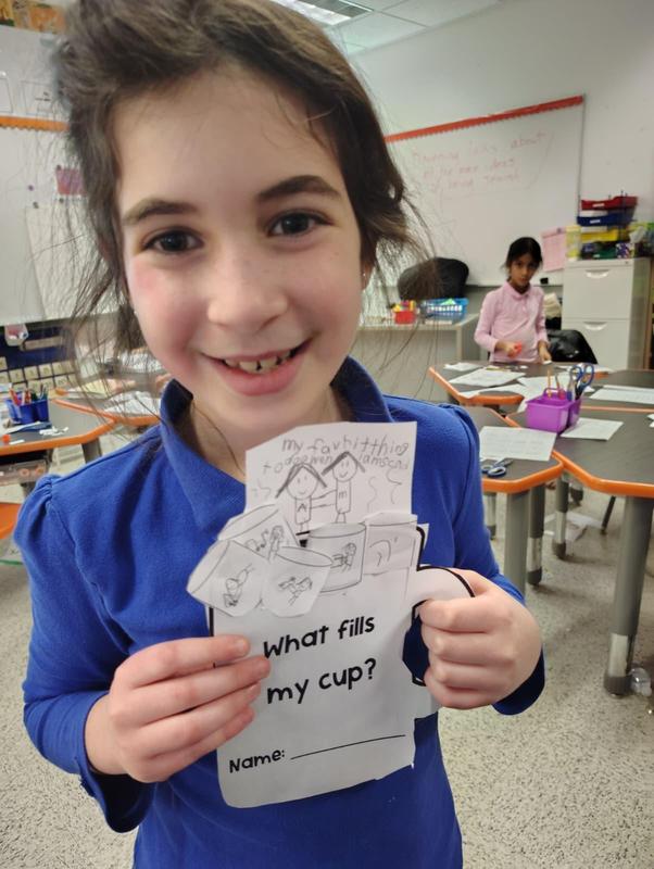 A second grade student displays her cup of calm.