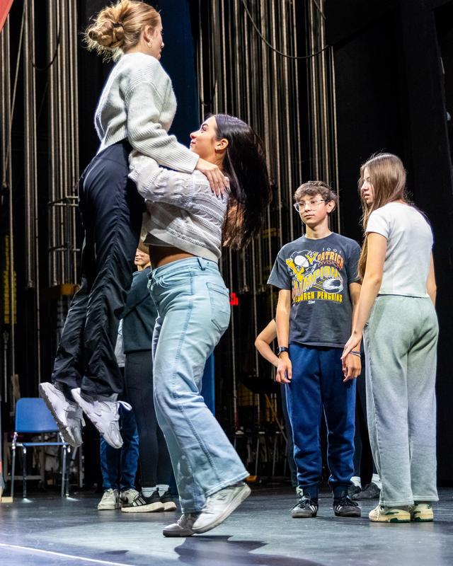 Livia lifts Gia to demonstrate a dance technique