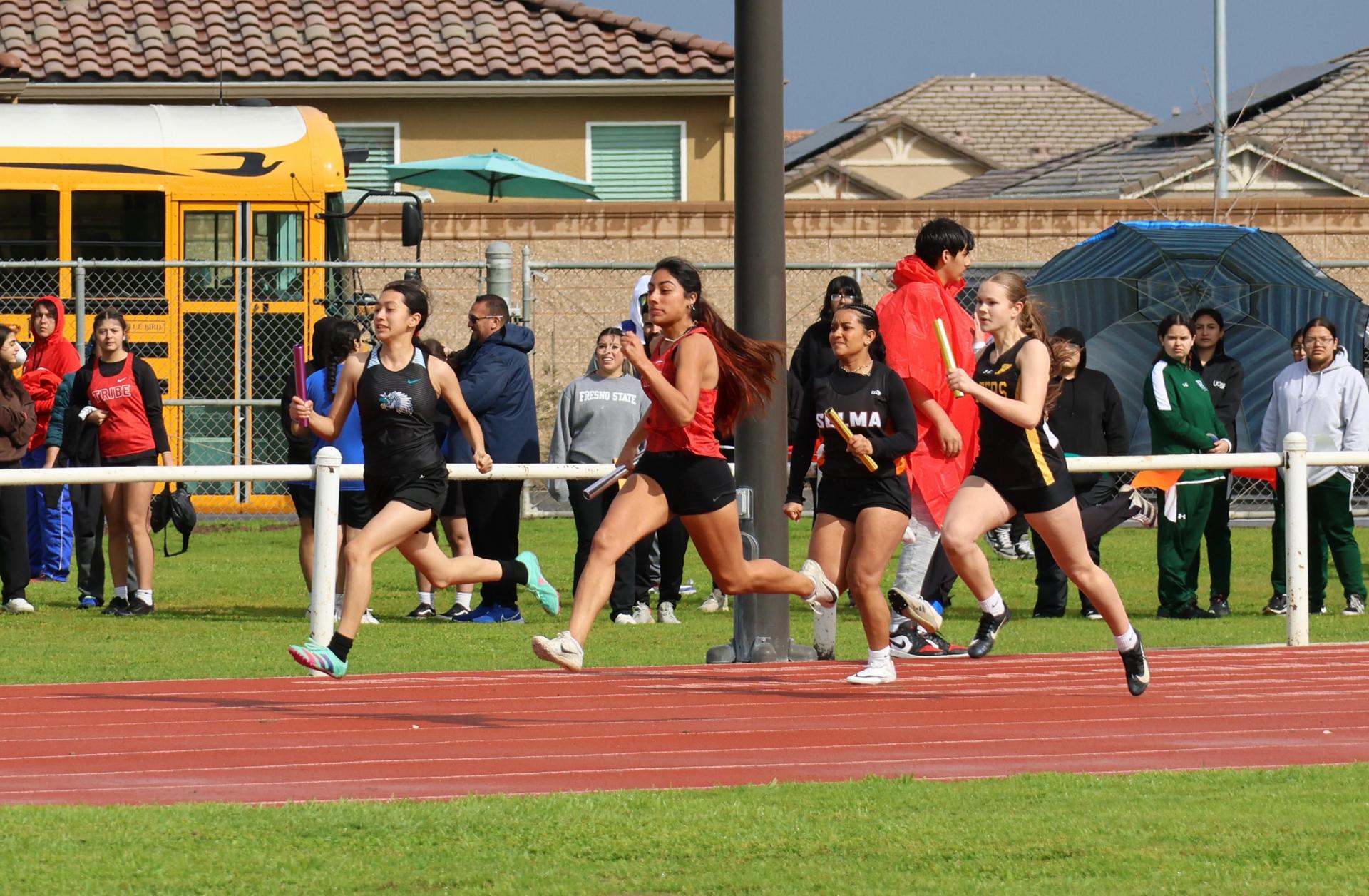 girls running the four by 100 meter relay