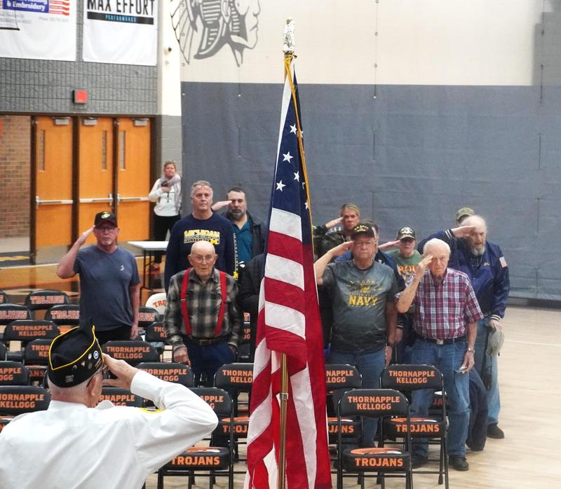 Veterans salute as the American flag is brought in.