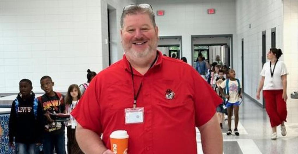 Principal in the hallway wearing red on independence day.