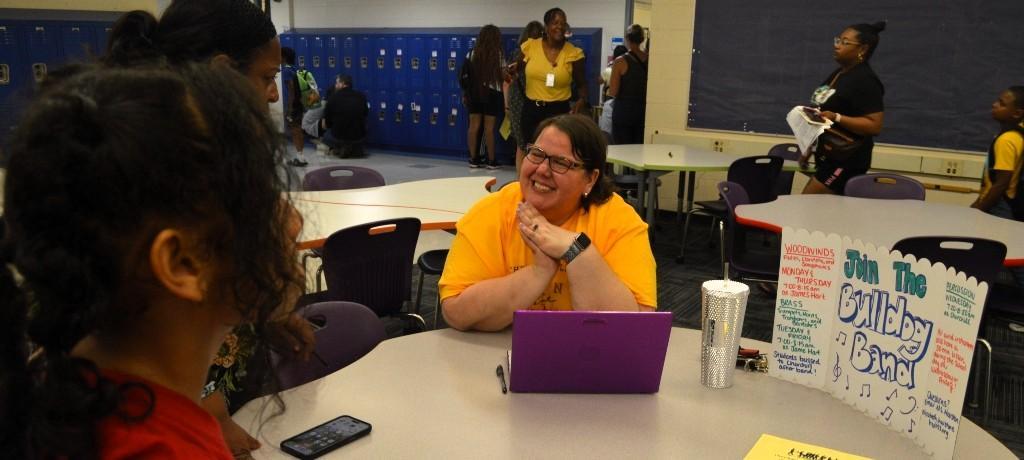 Teacher talks to two students about joining the band.