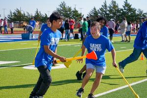 Frenship special educations students running around playing field hockey at adaptive field day.