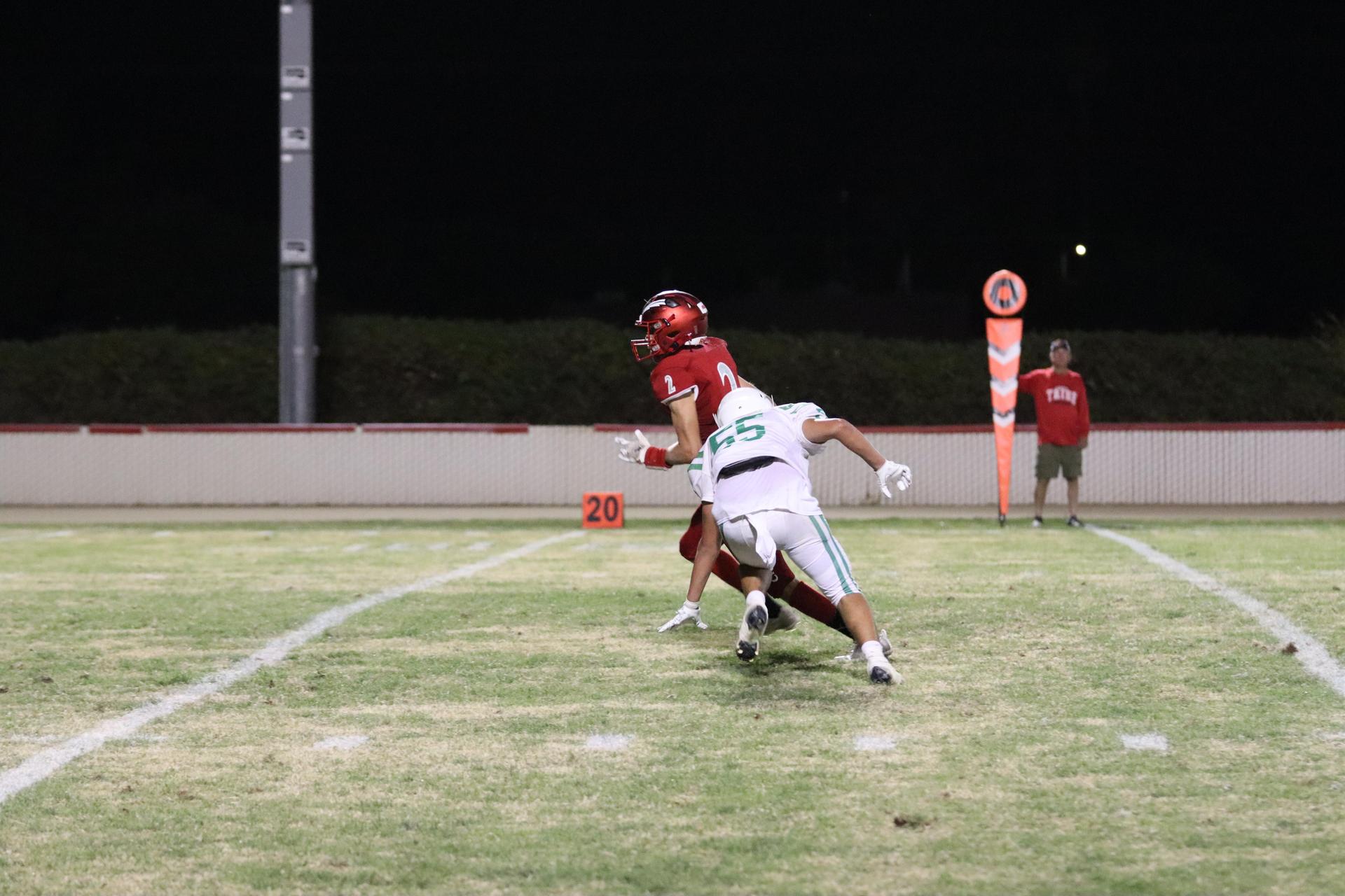 varsity football players in action against Riverdale