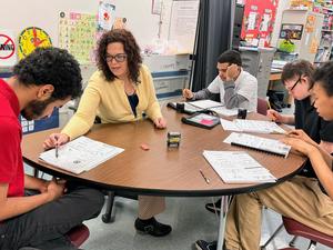 christine sitting at a table with 3 students