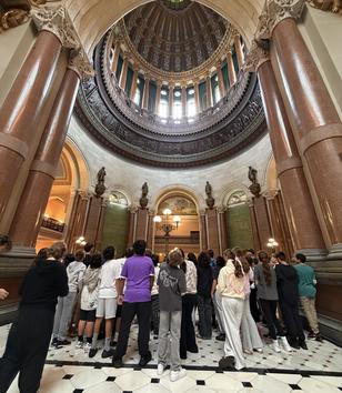 Students stare up at the ceiling of a beautiful building