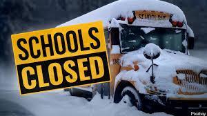 Snow-covered school bus with a 'Schools Closed' sign.