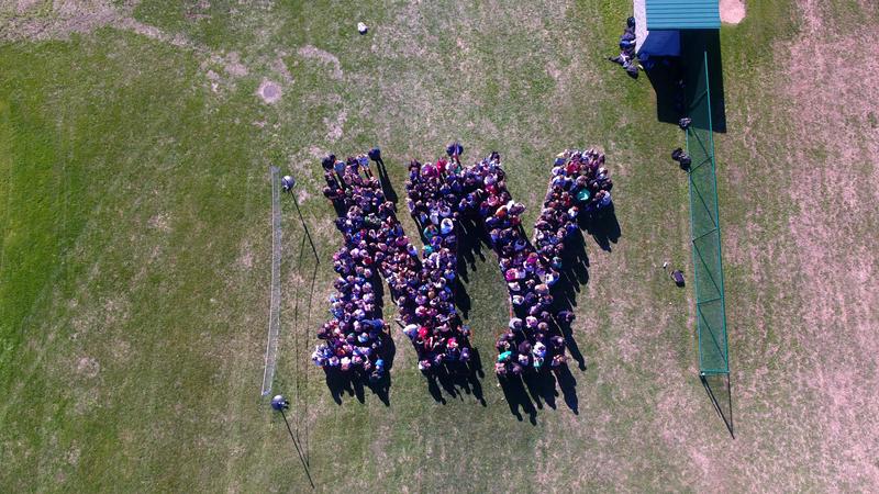 Students form an NY in the grass outside MCS