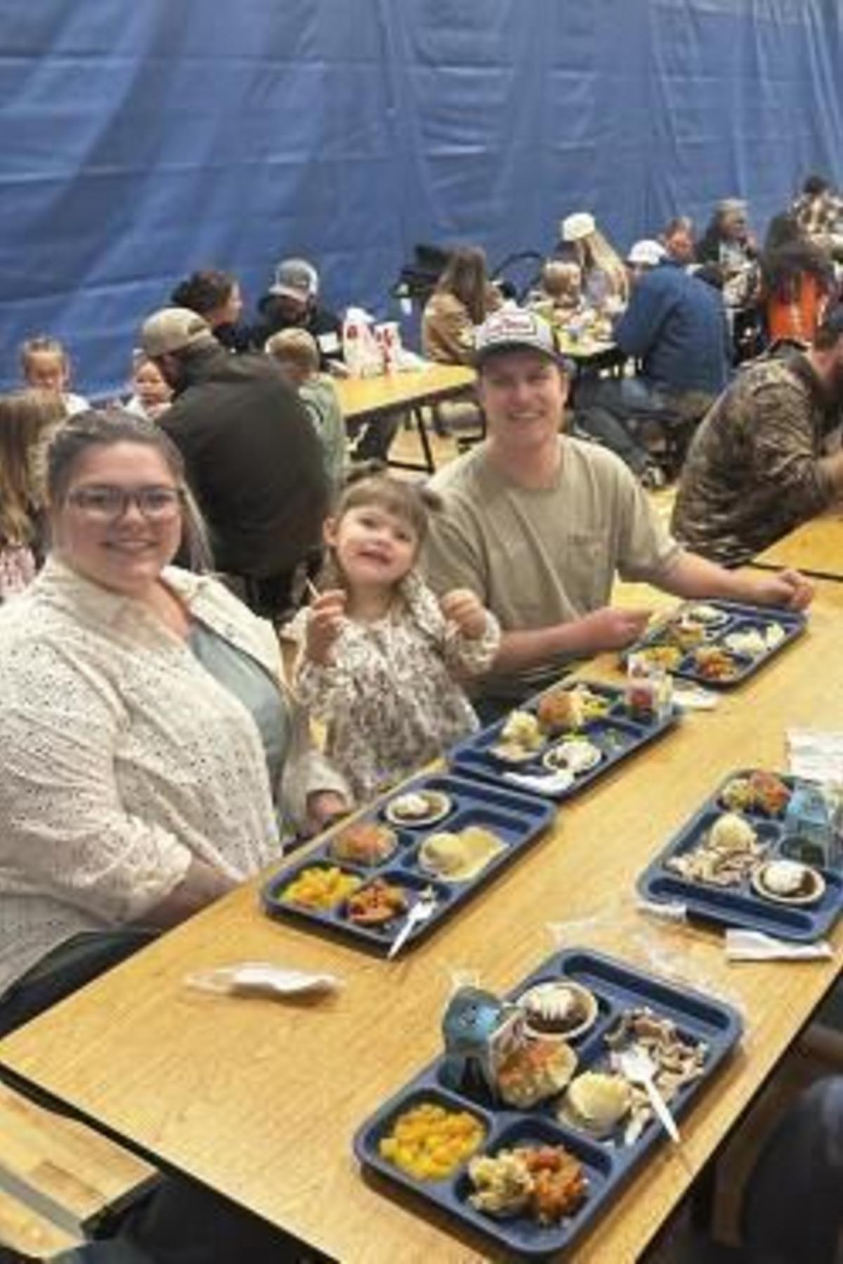 A family enjoying a meal together at a communal dining setting.