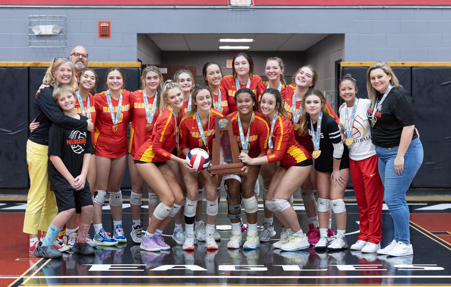  2022 girls volleyball state championship team posing with trophy