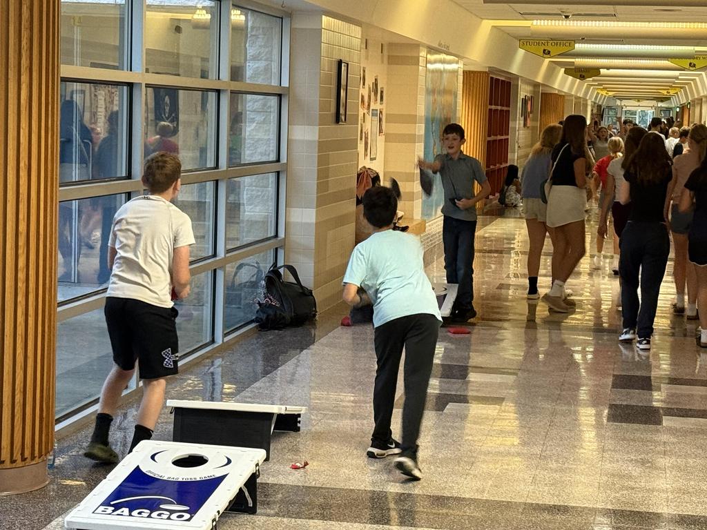 Students playing cornhole in the hallway at Teen Night Out.
