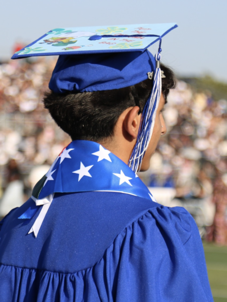 A young, Latino wearing a cap and gown