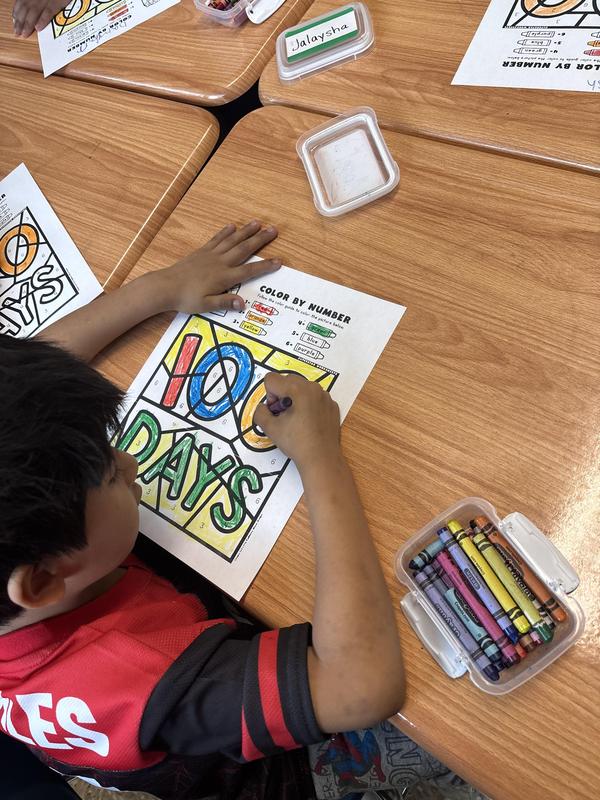 Students with a coloring page of 100 days