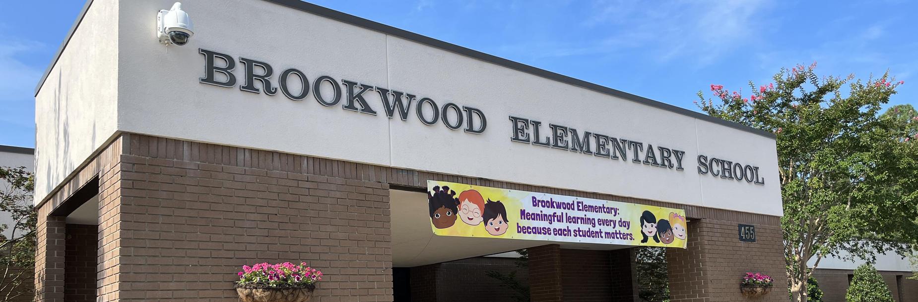 Brookwood Elementary School entrance with a colorful banner and flower baskets.
