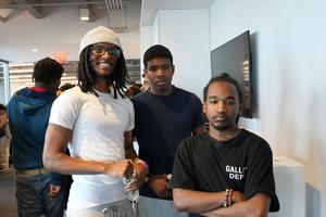 Three young men standing side by side, smiling at the camera.