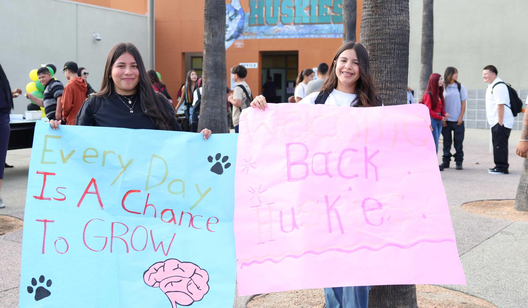 students holding welcome back to school signs