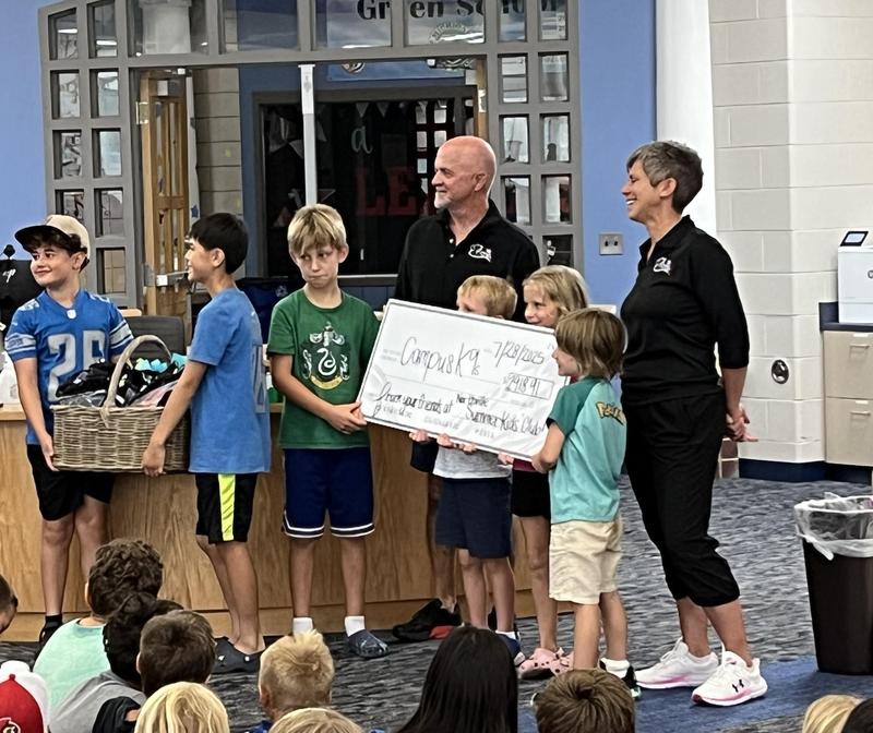 Students giving large check to Campus K9s