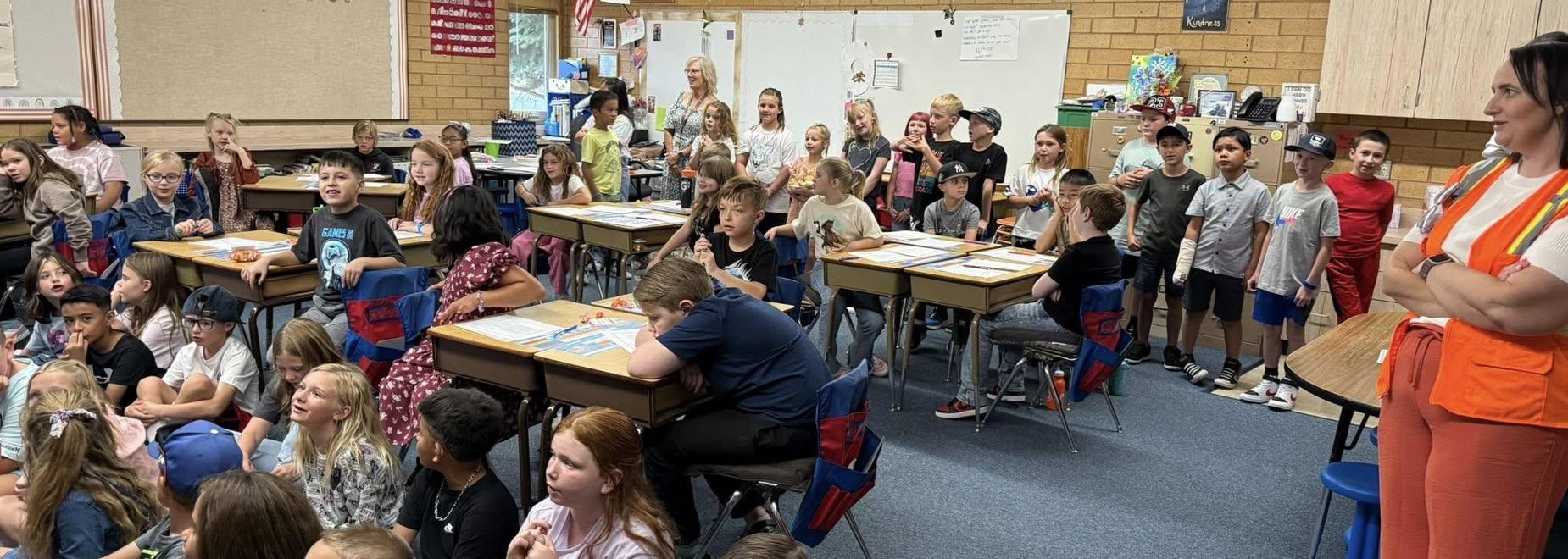 A lively classroom filled with students engaged and interacting with their teacher.