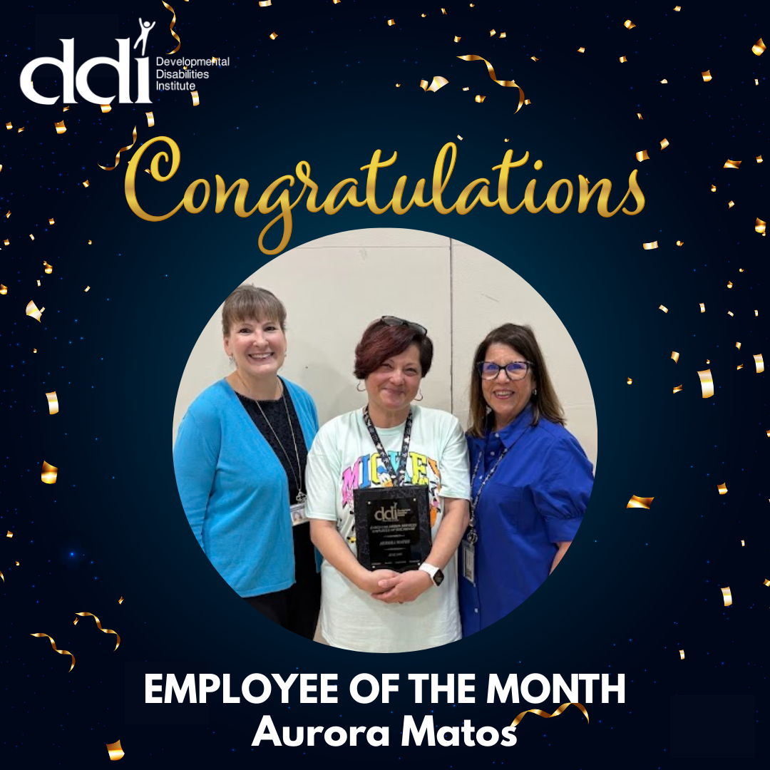 Picture of three smiling women. The woman in the middle is holding her Employee of the Month plaque