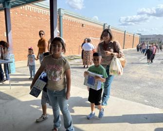 Students and mom holding school supplies