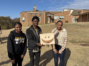 Three students standing with their pinata