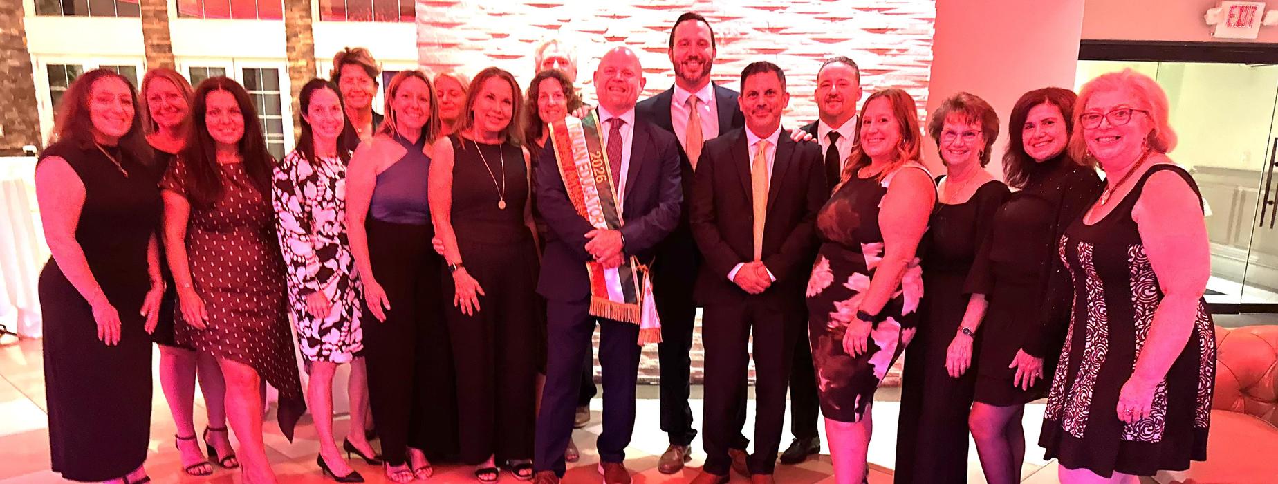 Group of people celebrating at an event, dressed in formal attire.