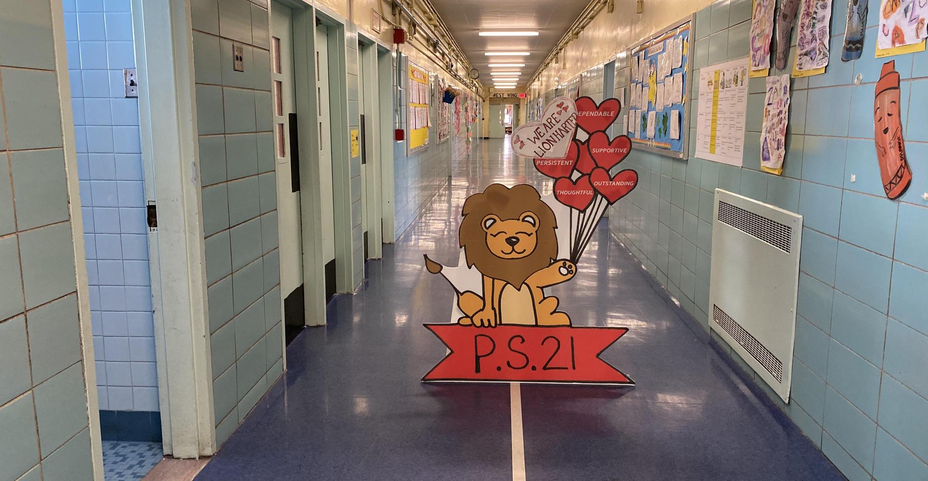 Hallway featuring a lion mascot holding balloons with colorful student artwork.