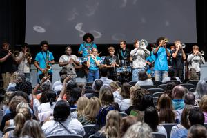 The marching band performs in the auditorium