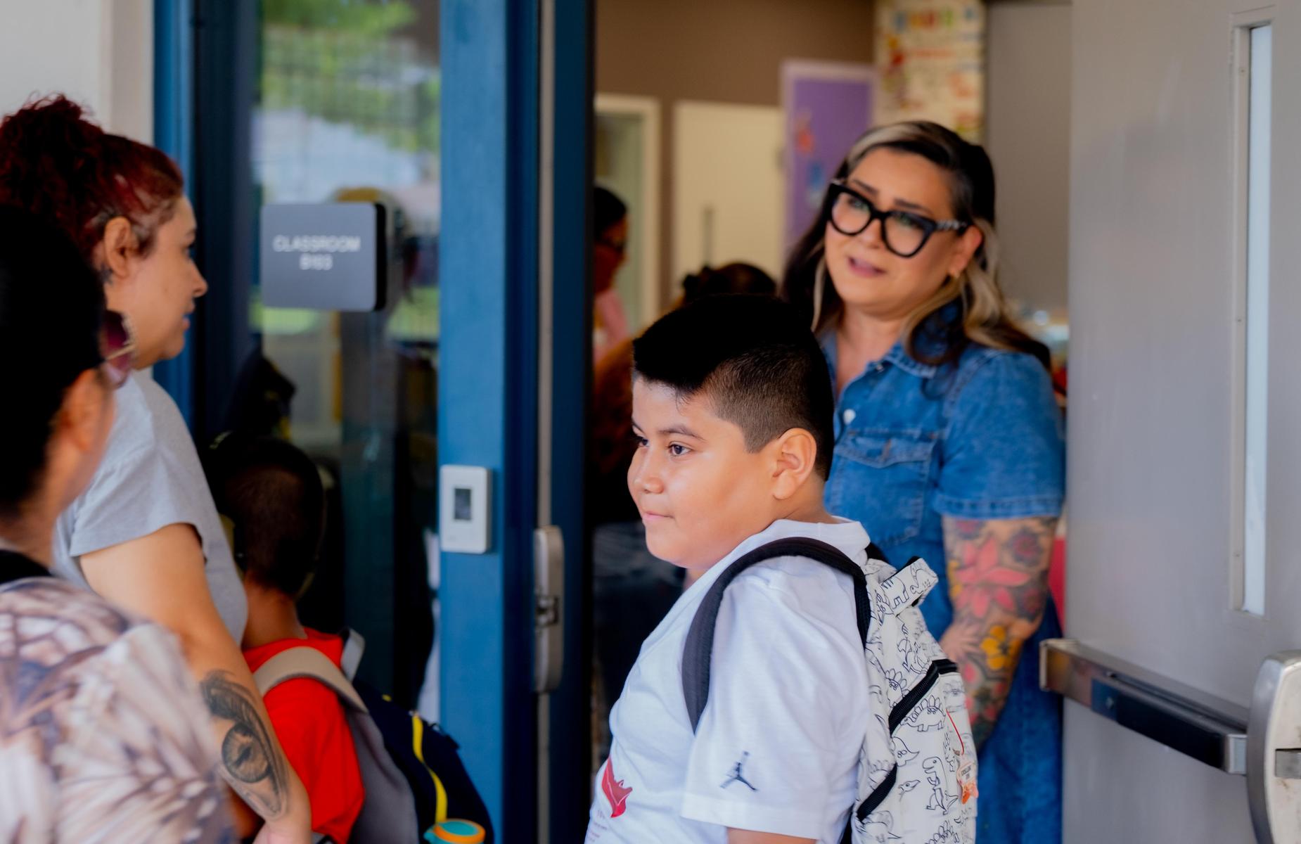 Student looks at mom and teacher in background