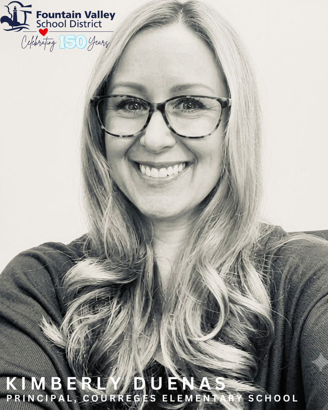 Black and white portrait of a smiling woman with long, wavy hair and glasses.