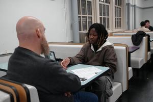 A man and a woman engaged in conversation at a dining table.