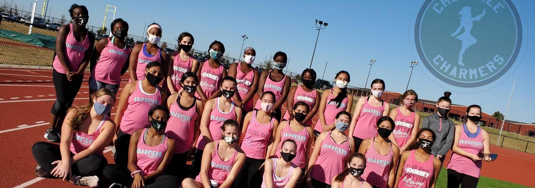 large group of teens wearing matching tank tops posing on the track
