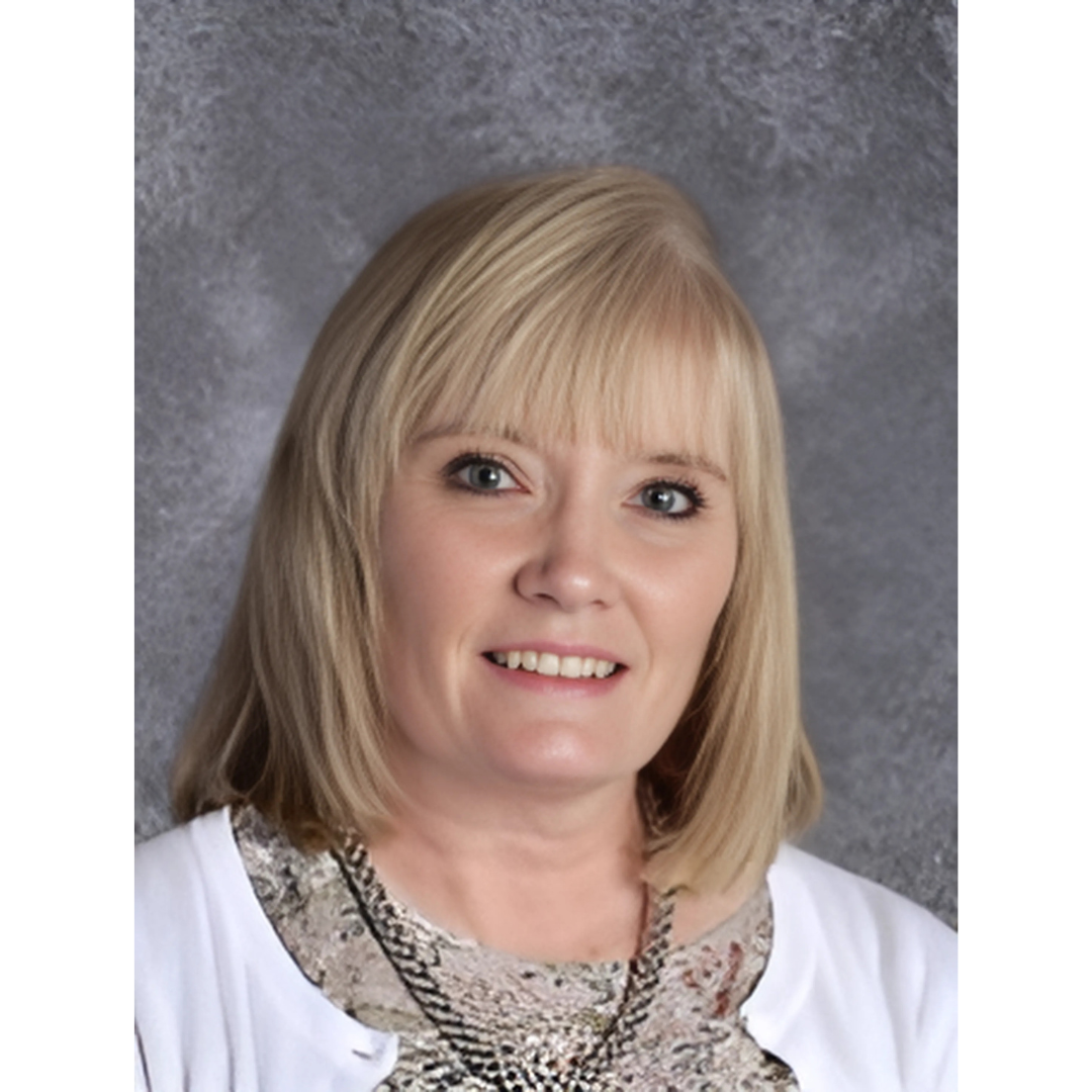 a person with blonde hair wearing a white cardigan