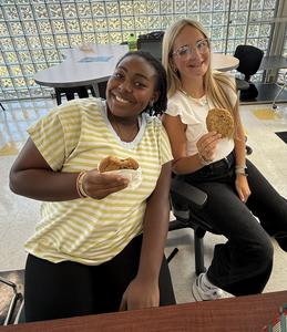 Two students smiling with their cookies.