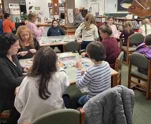 Children and adults engage in creative activities at tables in a library.