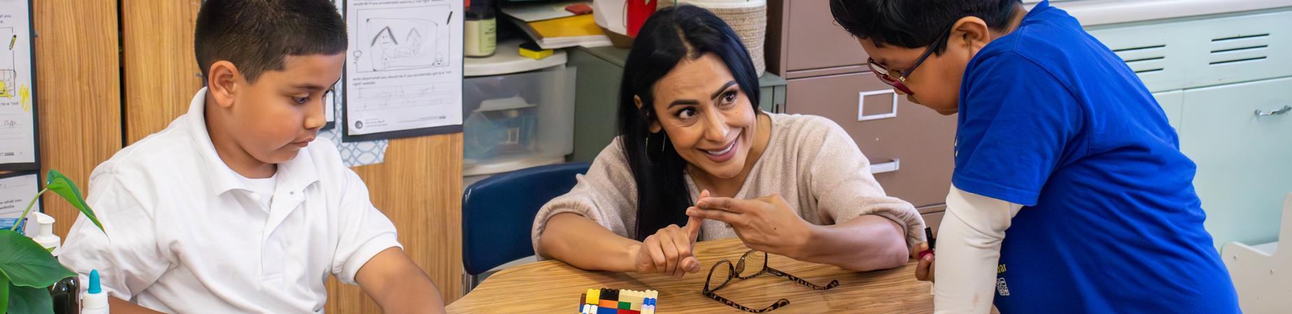 Female teacher with 2 boys in classroom