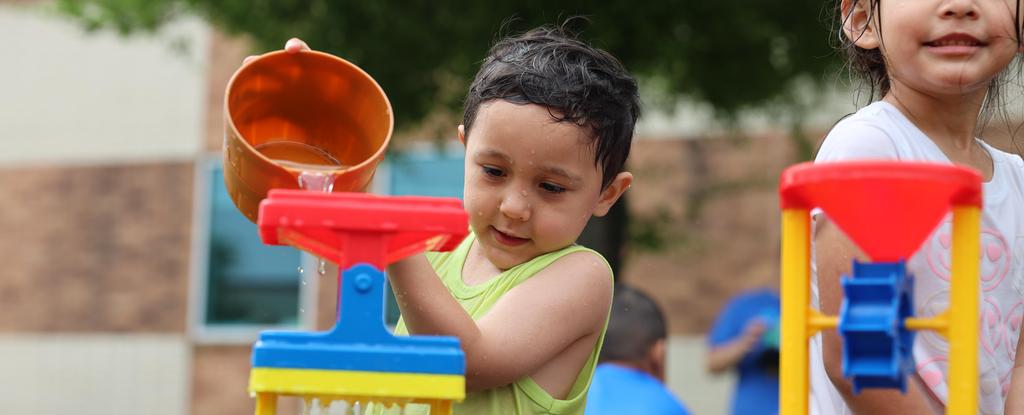 Child pouring water during a water day activity