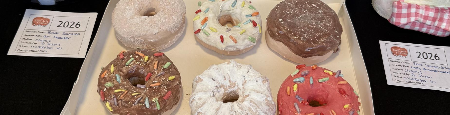 Close-up of a donut box with assorted colorful donuts inside.