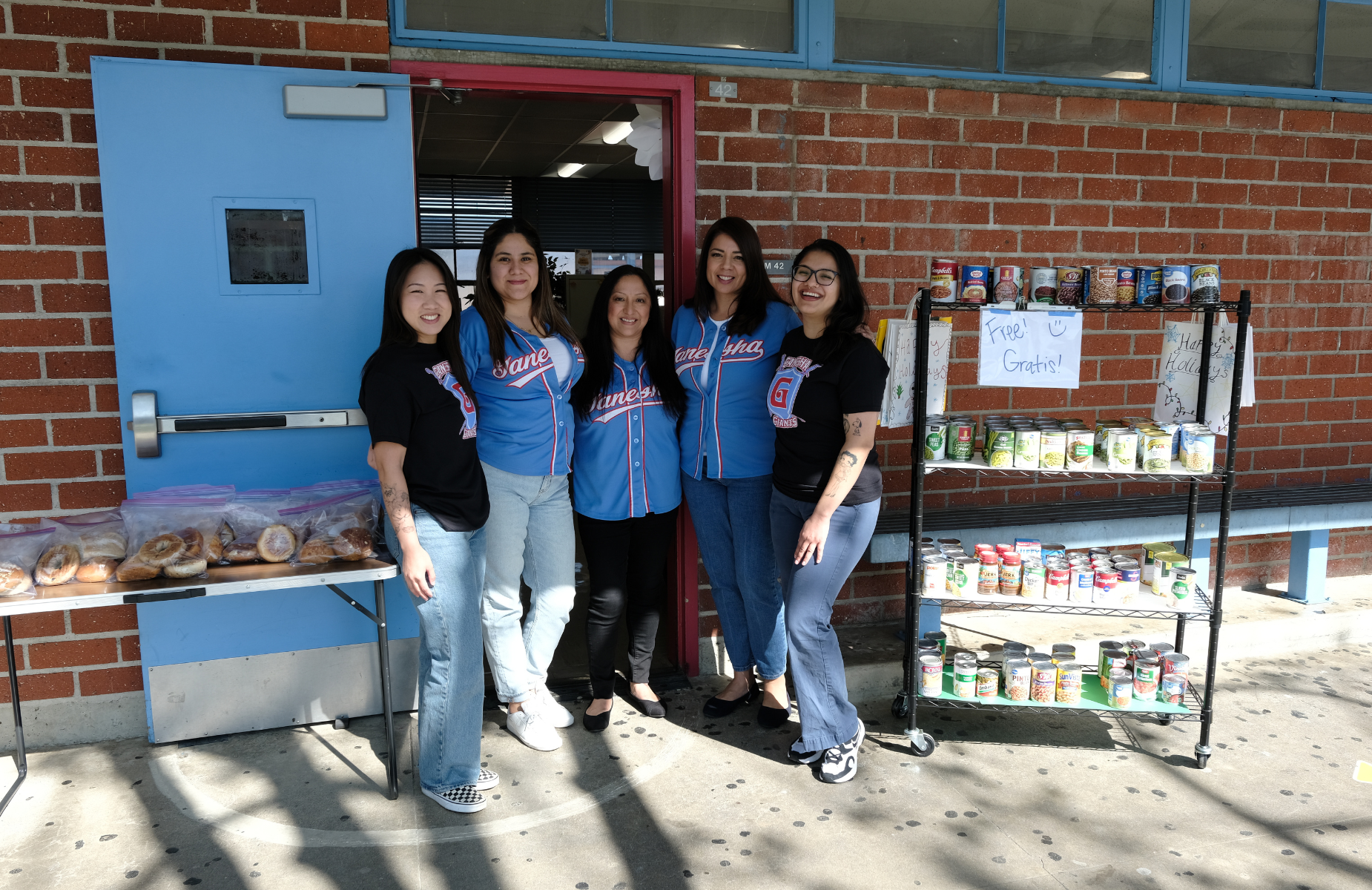 Ganesha High School Community Schools Team - pictures in front of their classroom of resource items for students