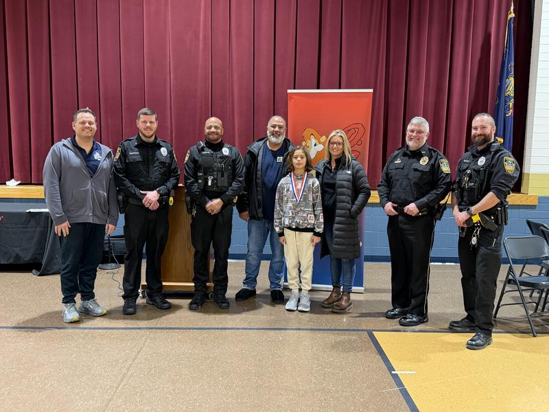 boy winner with medal on surrounded by police and parents