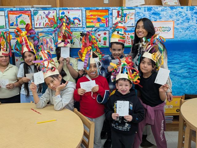 group of students with art work and sculpture hats