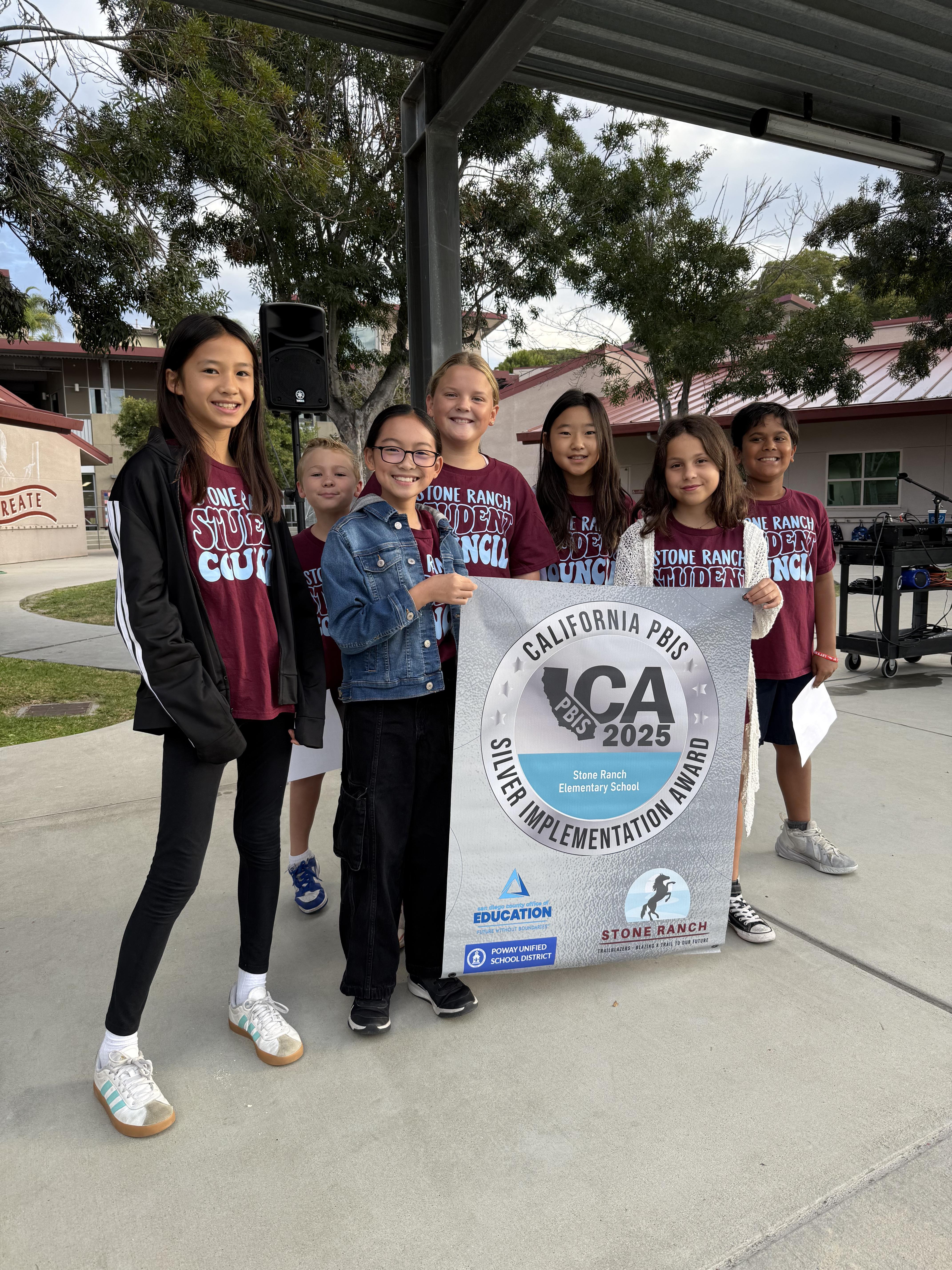 Students with Silver Award PBIS banner