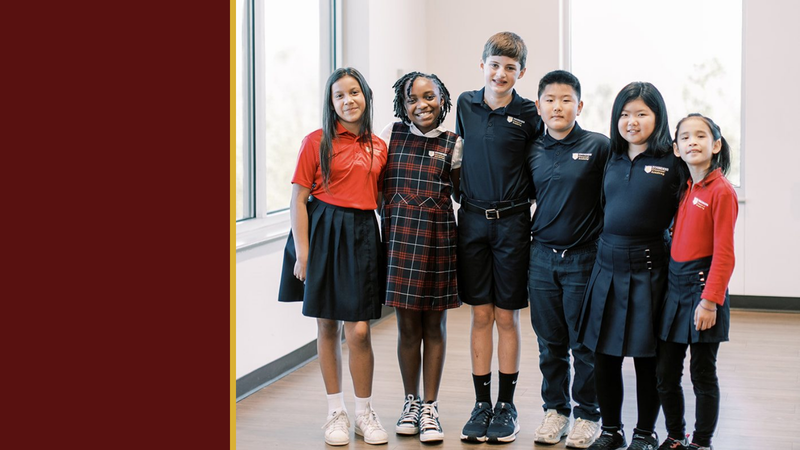 Smiling students in uniform stand together in a bright room