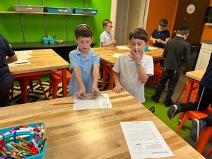 A student exerts pressure on his hopper popper using rubber bands.