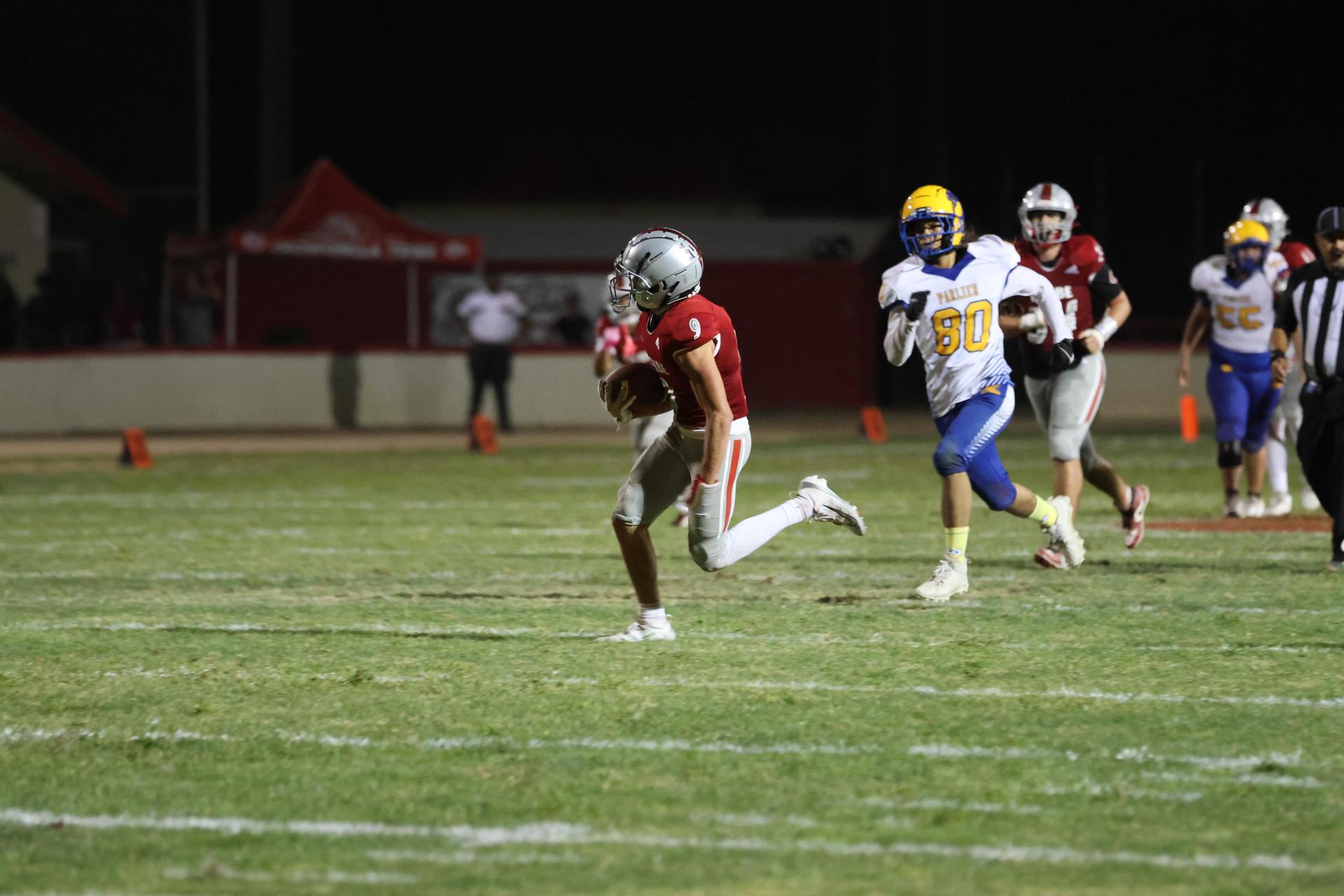 Varsity football players in action against Parlier 48